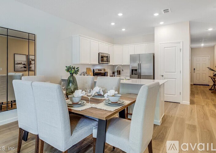 A modern kitchen with a dining table set for two.
