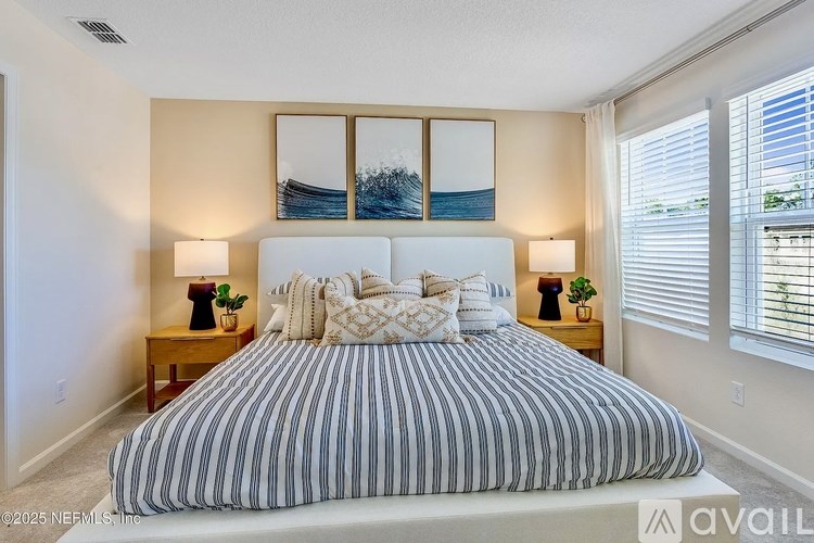 A bedroom with a large bed and two nightstands with lamps.