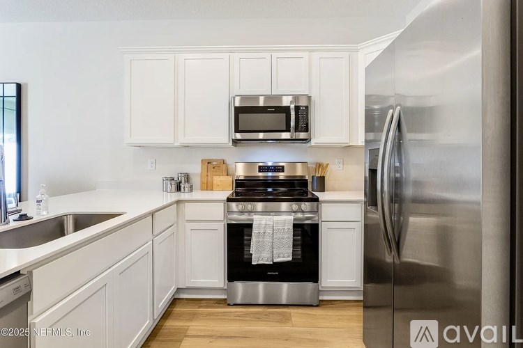A kitchen with white cabinets and stainless steel appliances.