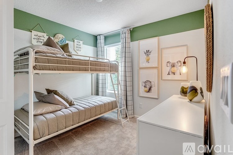 A room with bunk beds and a desk.