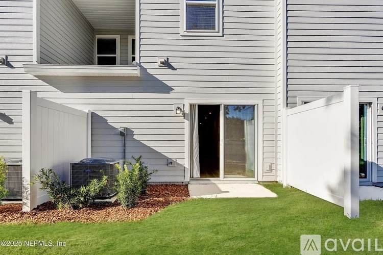 A modern house with a grey exterior and a white fence.