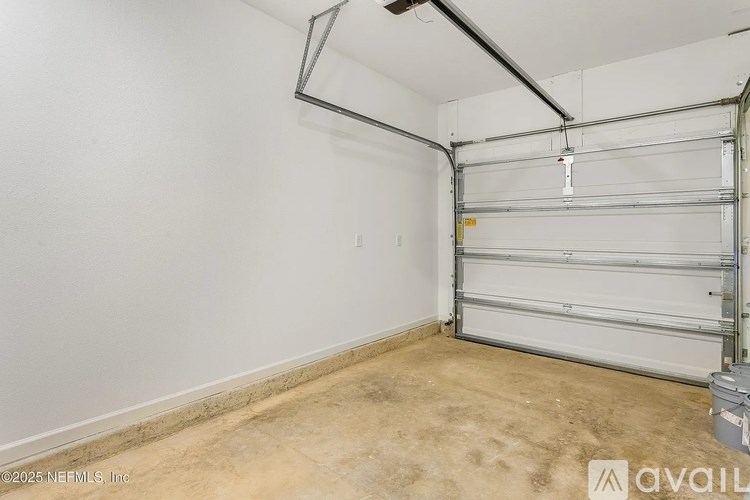 A garage with a white wall and a white door.