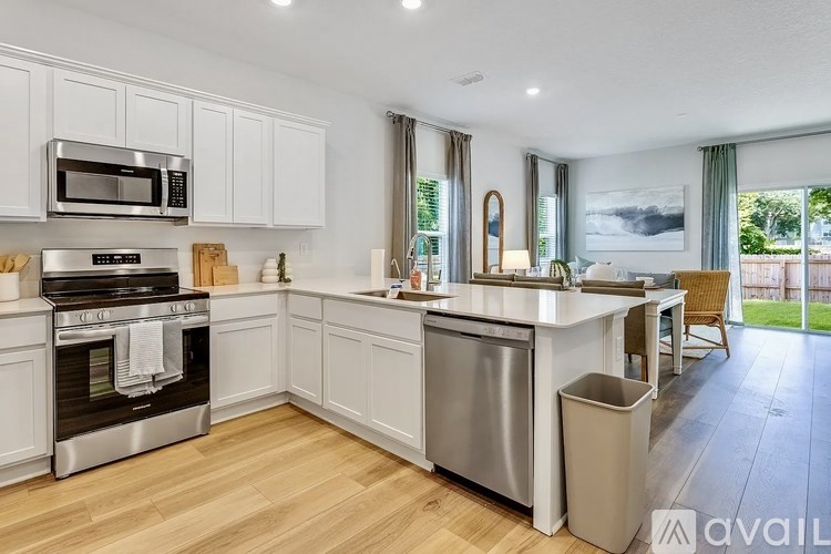 A modern kitchen with white cabinets and stainless steel appliances.