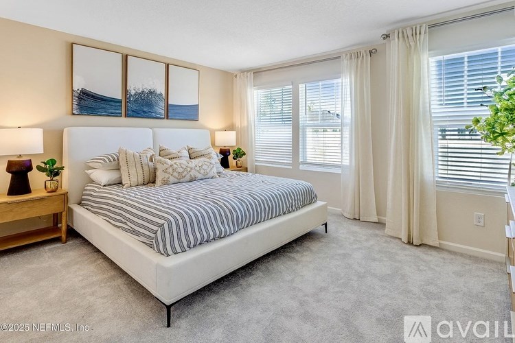 A bedroom with a large bed and a painting on the wall.