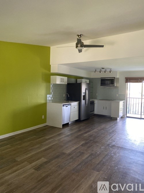 A living room with a green wall and a wooden floor.