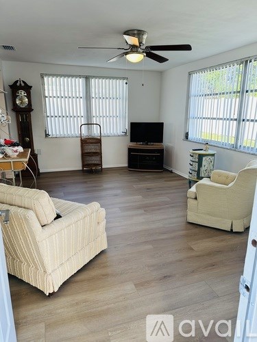 A living room with a sofa, chair, and television.