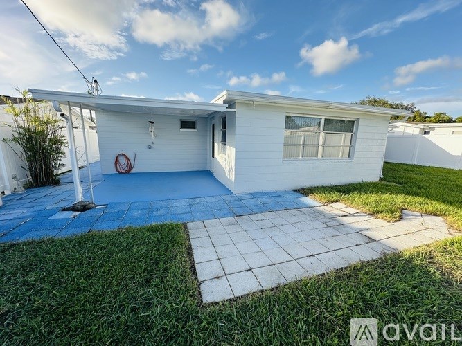 A small white house with a blue tiled patio.