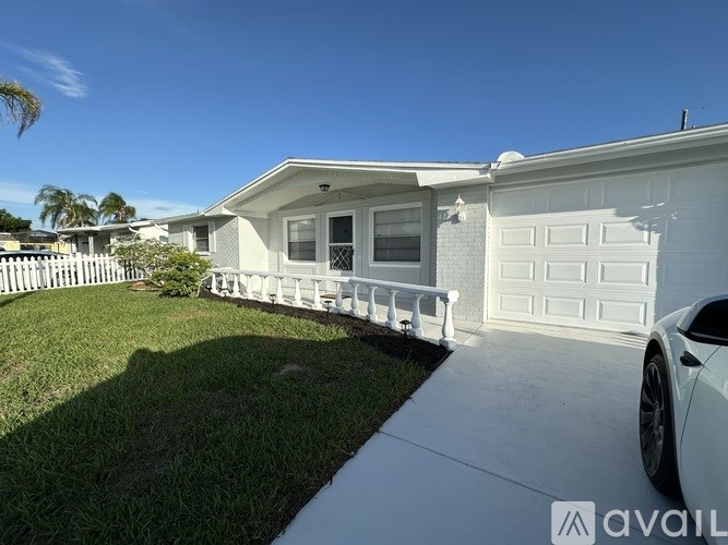 A white house with a car parked in front.