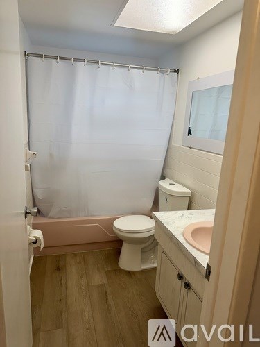 A bedroom with a bed, dresser, and a ceiling fan.