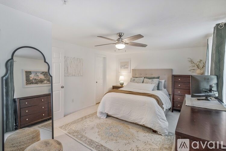 A bedroom with a large bed, a dresser, and a mirror.
