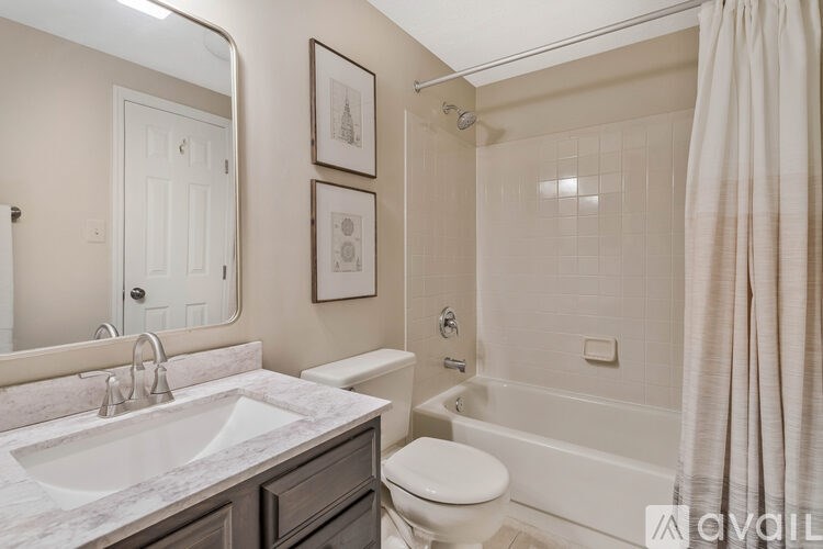 A bathroom with a white toilet, sink, and bathtub.