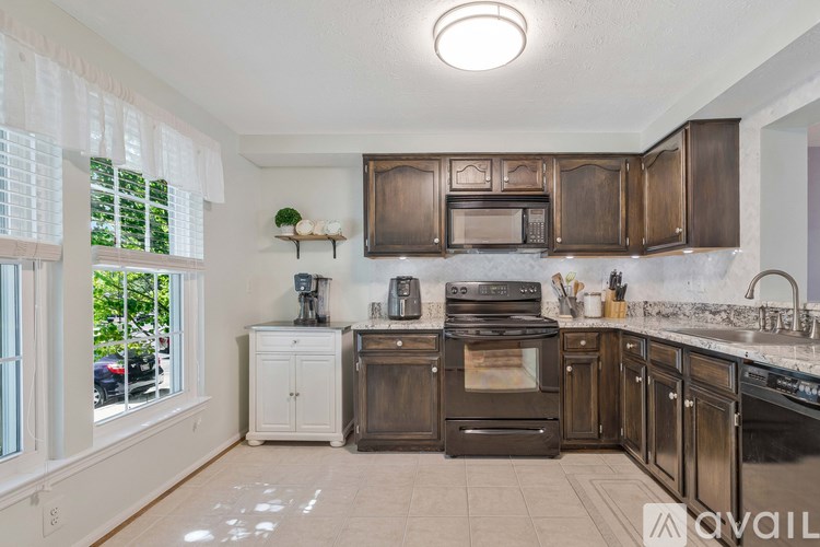 A kitchen with brown cabinets and a black stove top oven.