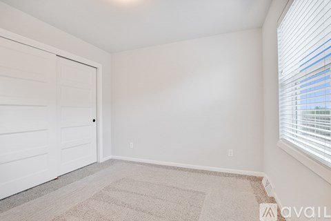 A room with a white door and a carpeted floor.