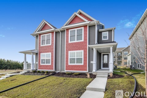 A two-story house with a red and gray exterior.
