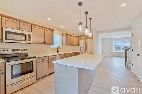 A modern kitchen with wooden cabinets and stainless steel appliances.