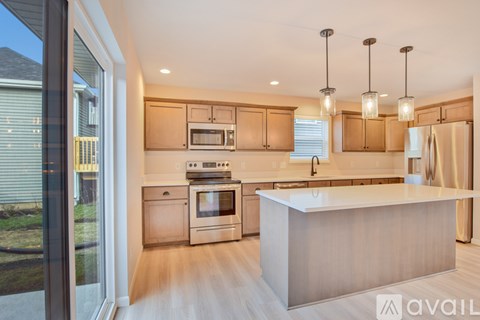 A modern kitchen with wooden cabinets and stainless steel appliances.