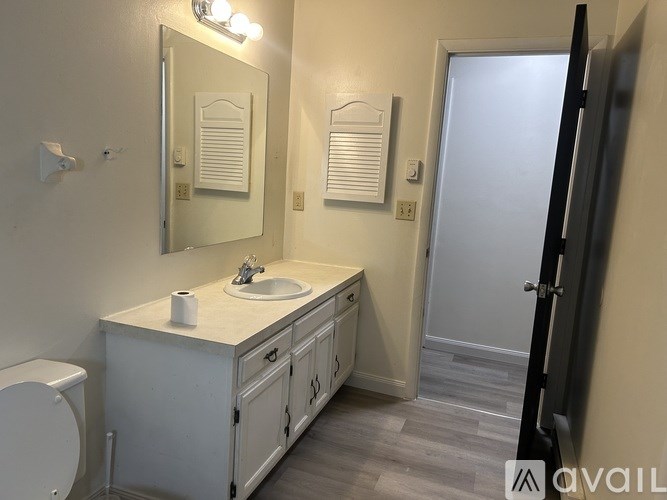 A bathroom with a sink, mirror, and toilet.