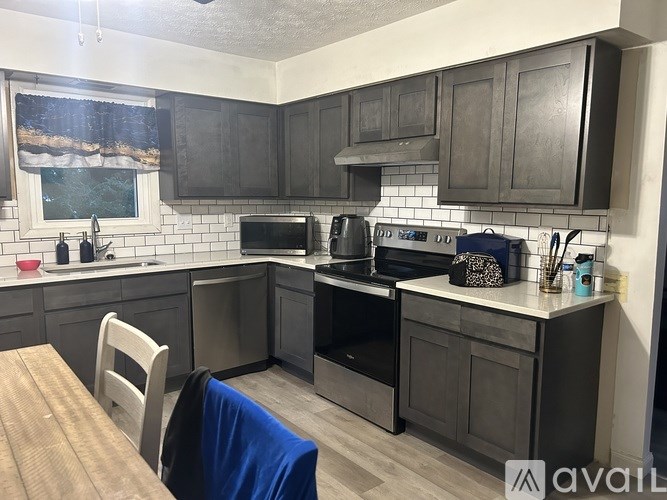 A kitchen with a wooden table and a window with a view of trees.