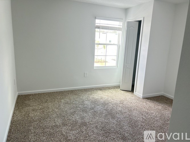 A room with a carpeted floor and a window.