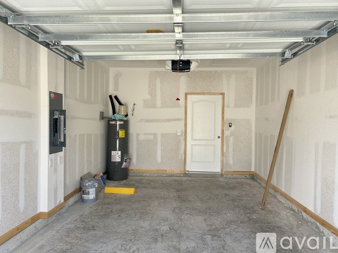 A garage with a white door, a black cabinet, and a yellow line on the floor.