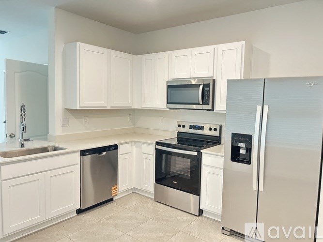 A kitchen with white cabinets and stainless steel appliances.