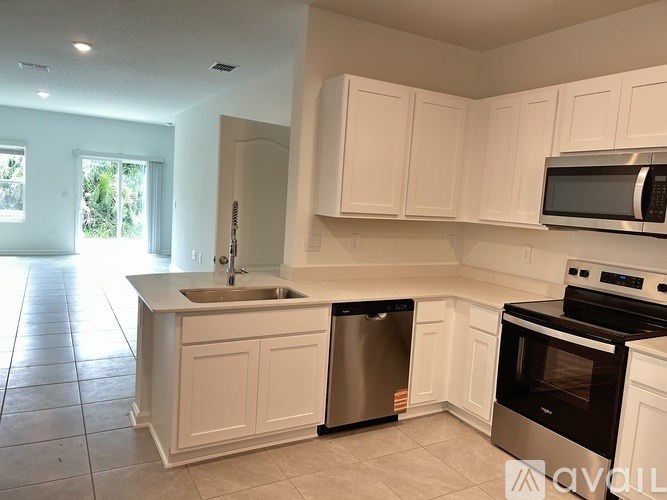 A kitchen with white cabinets and a stainless steel dishwasher and oven.