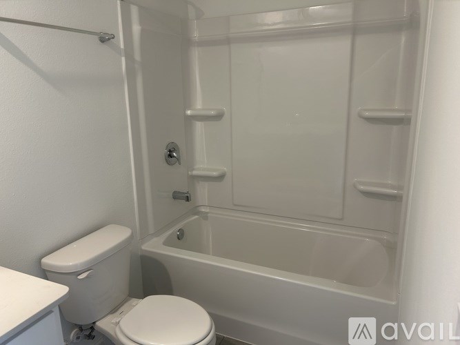A white toilet sits next to a bathtub in a bathroom.