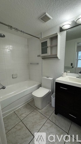 A room with a white wall and a wooden floor with a doorway leading to another room.