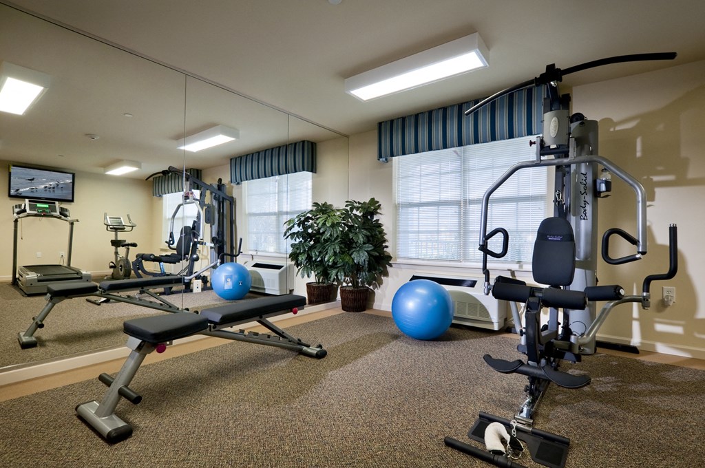 a gym with weights and exercise equipment at the community center