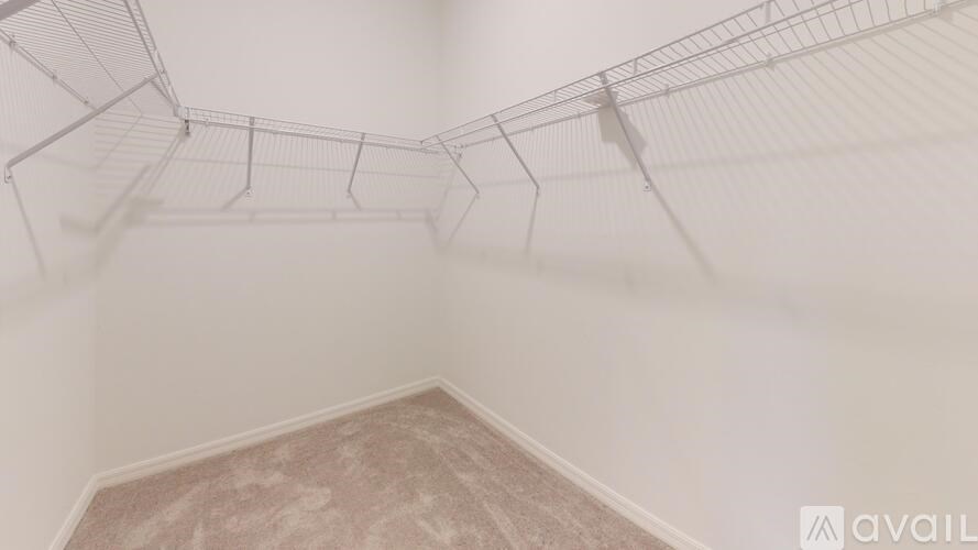 A room with a wire shelving unit and a carpeted floor.
