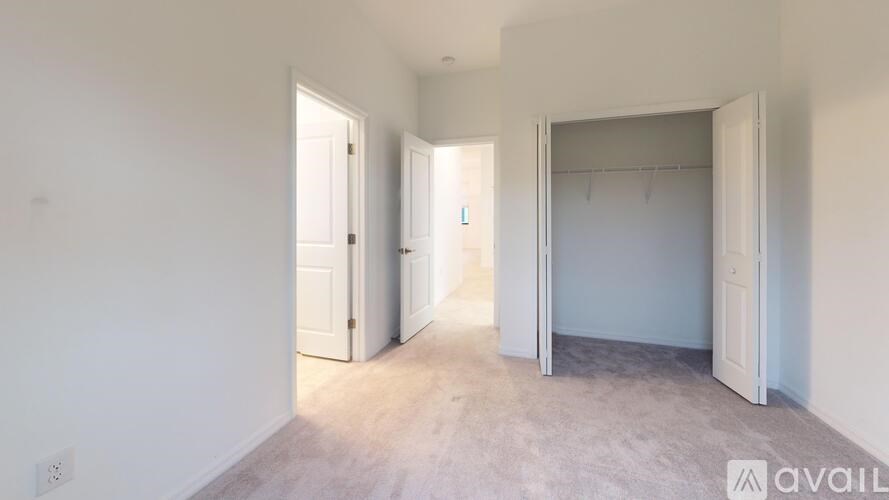 A room with three open doors and a carpeted floor.