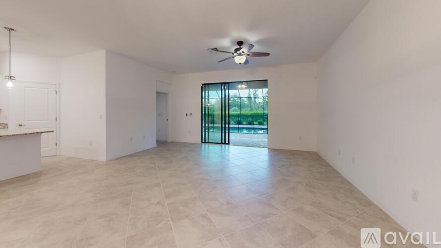 A spacious room with a ceiling fan and a large window.