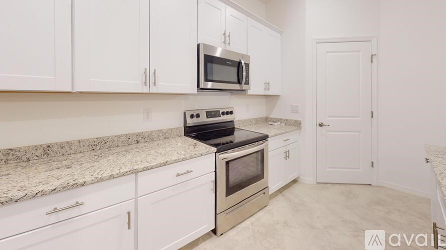A kitchen with white cabinets and a granite countertop.