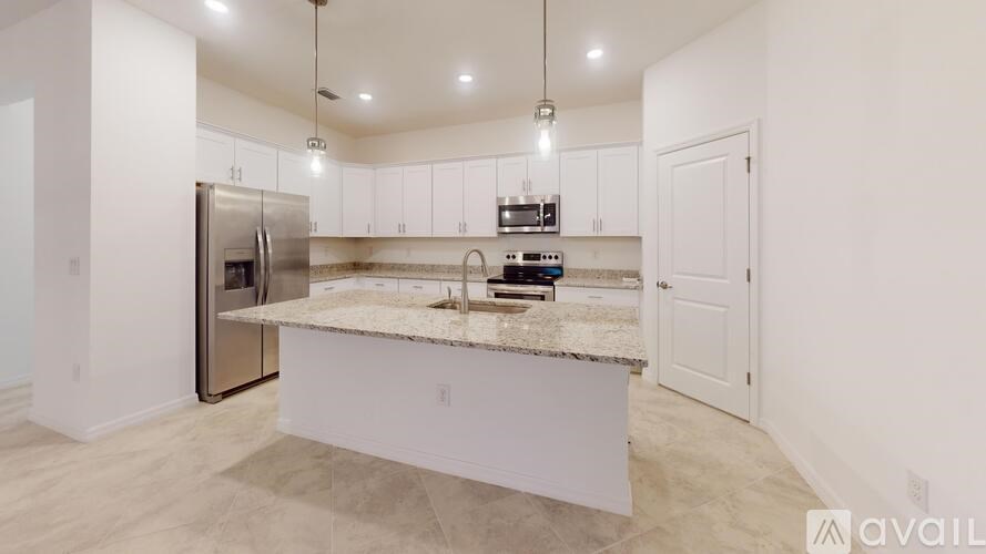 A kitchen with a granite countertop and stainless steel appliances.