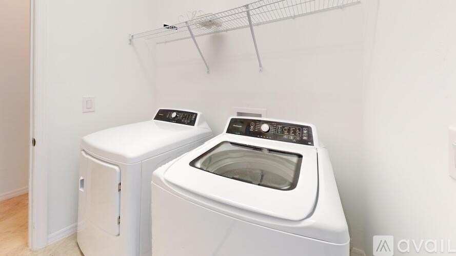 A white washing machine and dryer in a laundry room.