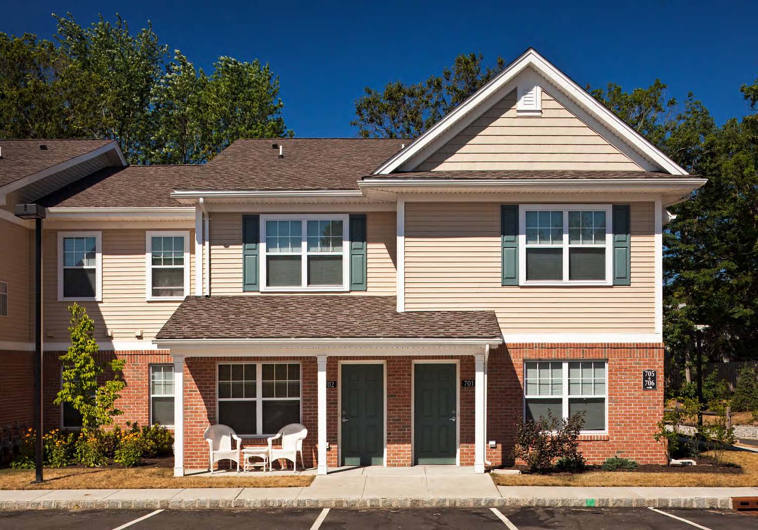 A two-story house with a red brick base and a beige upper section.