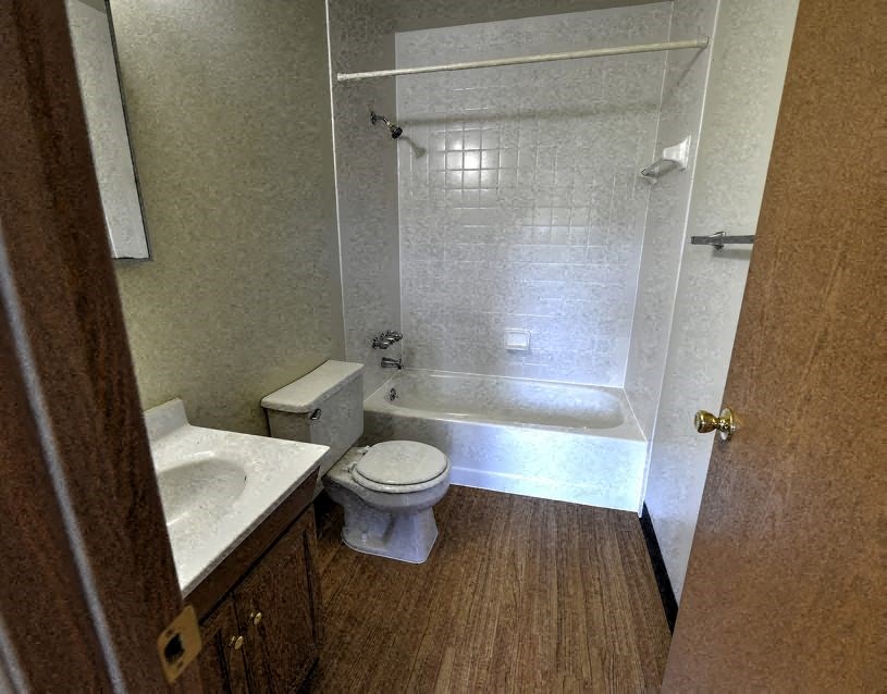 a bathroom with a toilet and a tub and a sink