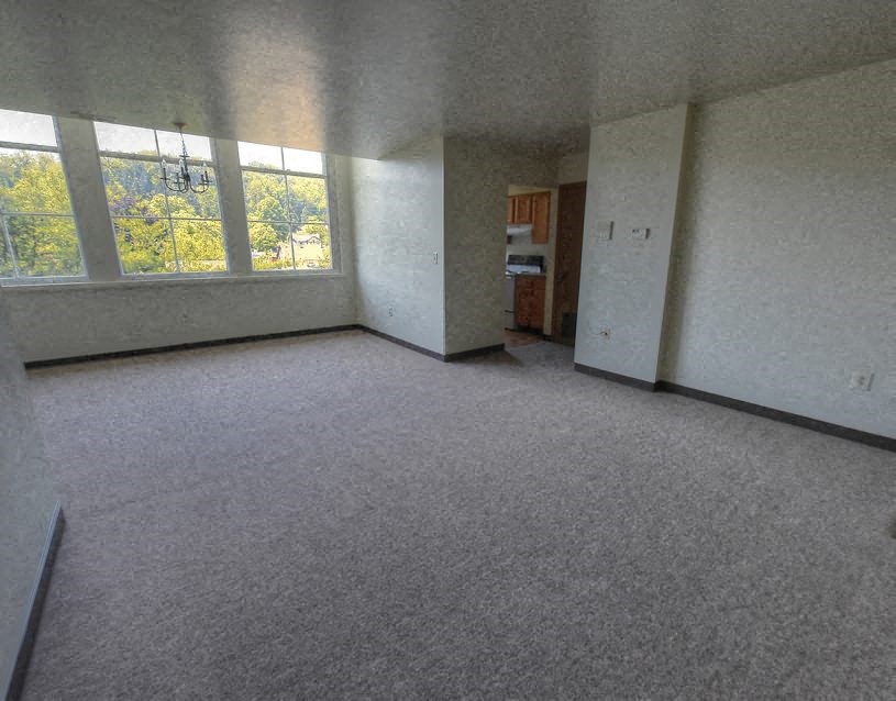 an empty living room with a large window