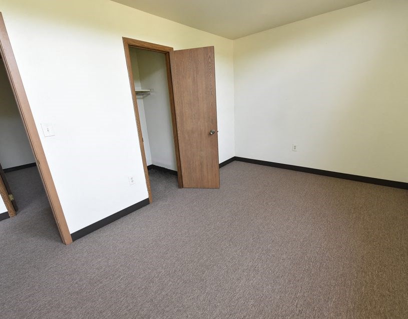 an empty room with a door to a closet