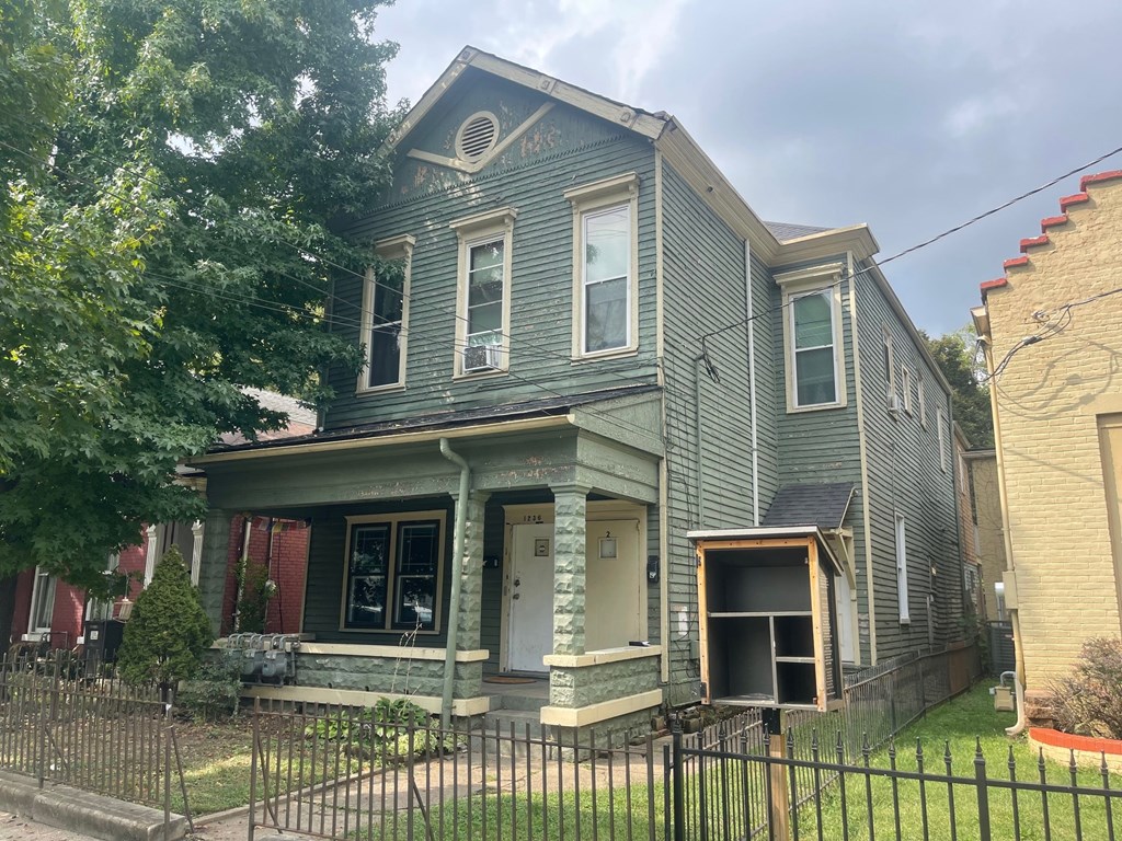 A grey house with a black fence in front.