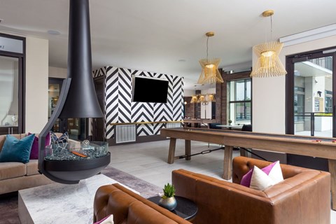A modern living room with a brown leather sofa and a black and white chevron wall.