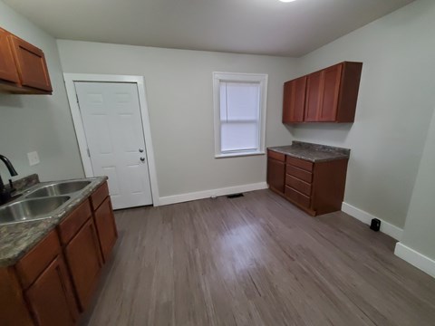 A kitchen with brown cabinets and a white door.