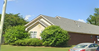 A house with a car parked in front.