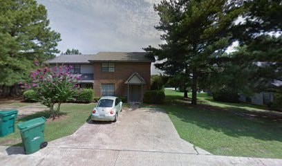 A car is parked in a driveway in front of a house.