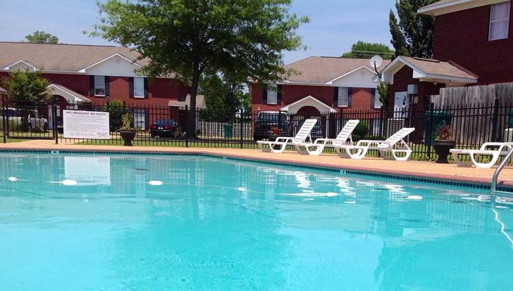 A pool with a sign in front of a house.