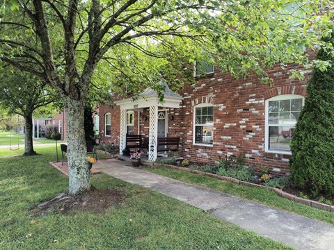 A brick house with a tree in front of it.