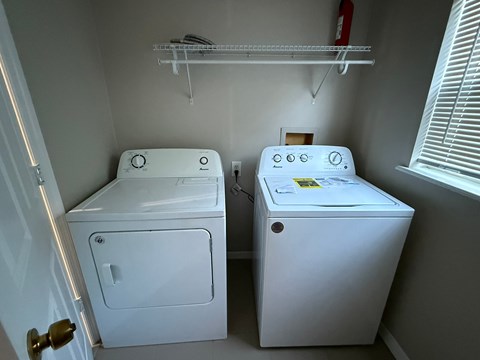 A white dryer and washer in a small laundry room.