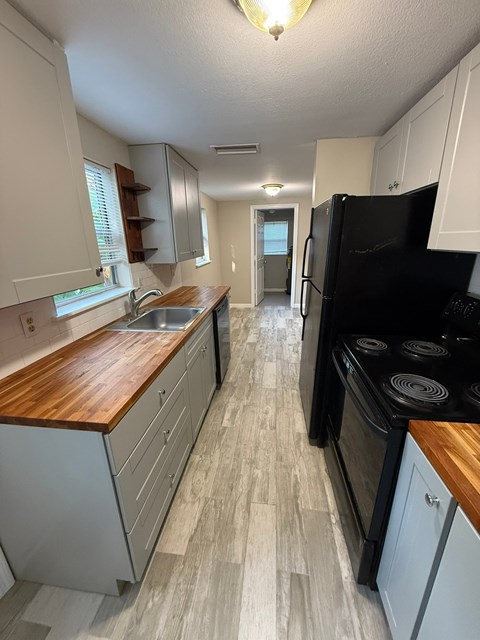 A kitchen with a black fridge and stove.