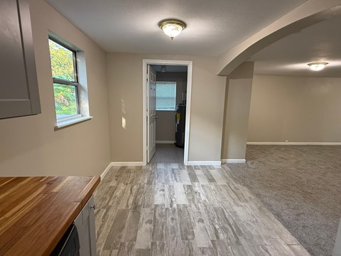 A room with a wooden counter top and a window with a view of trees outside.