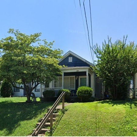 A blue house with white trim and a white porch.